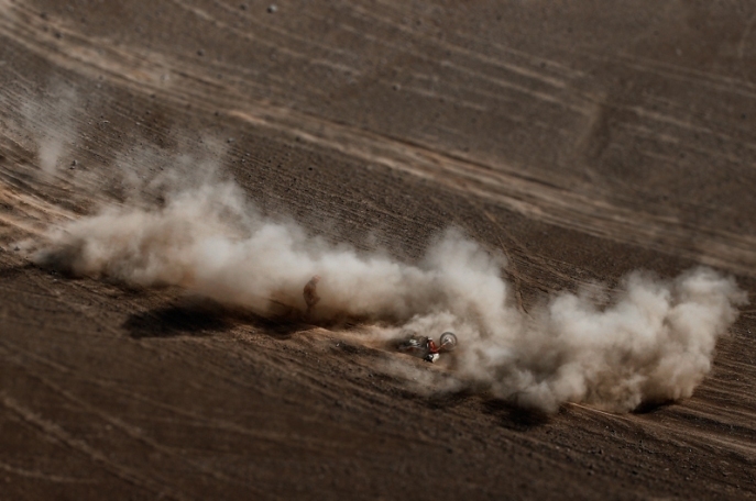 Foto: www.dakar.com;Joan Barreda Bort (Honda) práve havaroval: seba i stroj po páde zbiera z prašného terénu;